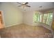 Carpeted bedroom featuring a ceiling fan, natural light from corner windows at 4704 Beech Crest Pl, Charlotte, NC 28269