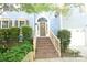 Close-up of front entrance with brick steps, a decorative wreath on the front door, and manicured bushes at 4704 Beech Crest Pl, Charlotte, NC 28269