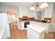 Bright kitchen features white cabinets, tile backsplash, an island, and views into the sunroom at 4704 Beech Crest Pl, Charlotte, NC 28269
