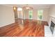 Open-concept living room with hardwood floors, fireplace and connecting foyer and dining room at 4704 Beech Crest Pl, Charlotte, NC 28269