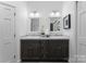 Bathroom with dual vanity sinks, large mirrors, and neutral colors at 4931 Pine Ridge Rd, Charlotte, NC 28226