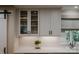 Close up of kitchen cabinets with glass fronts, a window, and counter with decor at 4931 Pine Ridge Rd, Charlotte, NC 28226