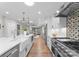Spacious white kitchen featuring a large island, modern appliances, and decorative tile backsplash at 4931 Pine Ridge Rd, Charlotte, NC 28226