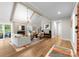 Bright living room with a brick fireplace, comfortable seating, and beautiful hardwood floors throughout at 4931 Pine Ridge Rd, Charlotte, NC 28226