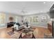 Bright living room boasts hardwood floors, a modern ceiling fan, and abundant natural light from large windows at 4931 Pine Ridge Rd, Charlotte, NC 28226