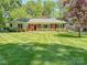 Charming brick home with a well-maintained lawn and mature trees at 5119 Beckford Dr, Charlotte, NC 28226