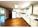 Bright kitchen featuring white cabinets, appliances, and hardwood floors at 5119 Beckford Dr, Charlotte, NC 28226