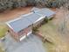 Aerial view of a brick home with an attached two-car garage, long driveway, and mature trees, providing ample parking at 5303 Rogers Rd, Monroe, NC 28110