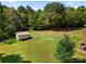 Aerial view of the spacious backyard with a storage shed and mature trees creating a serene and private outdoor space at 5303 Rogers Rd, Monroe, NC 28110