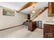 Basement bar area with wood trim, cabinets, bar seating, and adjacent staircase at 5303 Rogers Rd, Monroe, NC 28110