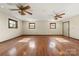 Bedroom with three windows, hardwood floors, and ceiling fans at 5303 Rogers Rd, Monroe, NC 28110
