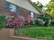 Charming brick home exterior showcases well-maintained landscaping and flowering bushes, and traditional architecture at 5303 Rogers Rd, Monroe, NC 28110