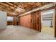 Exposed unfinished basement with pink insulation and utility hookups at 5303 Rogers Rd, Monroe, NC 28110
