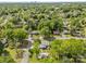 An aerial view showcases a neighborhood with tree-lined streets and distant city skyline at 6035 Idlebrook Dr, Charlotte, NC 28212