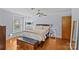 This main bedroom includes wood floors, a large bed, and a dark-wood storage chest at 6035 Idlebrook Dr, Charlotte, NC 28212
