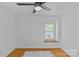 Bright bedroom featuring hardwood floors, a ceiling fan, and a sun-filled window for natural light at 6035 Idlebrook Dr, Charlotte, NC 28212