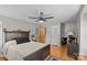 Spacious bedroom features hardwood floors, a ceiling fan, a dark wood bed frame, and a large window at 6035 Idlebrook Dr, Charlotte, NC 28212