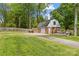 Large detached brick garage with a spacious driveway and backyard deck for outdoor enjoyment at 6035 Idlebrook Dr, Charlotte, NC 28212