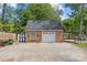 Detached brick garage with white doors and a paved driveway, offering ample parking and storage space at 6035 Idlebrook Dr, Charlotte, NC 28212