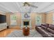 Comfortable living room showcasing hardwood floors, a white brick fireplace, and ample natural light with modern ceiling fan at 6035 Idlebrook Dr, Charlotte, NC 28212