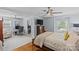 Bright main bedroom with hardwood floors, fan, tv, and attached office space at 6035 Idlebrook Dr, Charlotte, NC 28212
