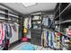 Custom walk-in closet features ample storage, shelving, and stylish organization with a light blue ottoman and wood floor at 6035 Idlebrook Dr, Charlotte, NC 28212