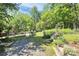 Landscaped backyard featuring a gardening area, mature trees, lush lawn, and plenty of sunshine at 729 Lochaven Rd, Waxhaw, NC 28173