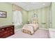Cozy bedroom with a vintage metal bed frame, striped wallpaper, and a decorative window treatment at 729 Lochaven Rd, Waxhaw, NC 28173