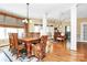Spacious dining room featuring hardwood floors, large windows, and traditional wood table with seating for eight at 729 Lochaven Rd, Waxhaw, NC 28173