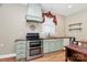 Custom kitchen with mint-green cabinetry, stainless steel appliances, and unique vent hood at 729 Lochaven Rd, Waxhaw, NC 28173