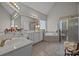 Primary bathroom boasts dual vanity, soaking tub, and glass enclosed shower at 7815 Scottsburg Ct, Mint Hill, NC 28227