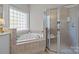 Primary bathroom boasts soaking tub and glass enclosed shower at 7815 Scottsburg Ct, Mint Hill, NC 28227