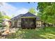 Charming rear exterior view featuring a screened porch and patio, nestled within a well-manicured lawn and greenery at 7815 Scottsburg Ct, Mint Hill, NC 28227