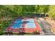 Aerial view of blue and red tennis courts surrounded by lush green trees and a parking lot at 7815 Scottsburg Ct, Mint Hill, NC 28227