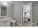 Bathroom with toilet and vanity sink, and door to light-filled bedroom at 8014 Avanti Dr, Marvin, NC 28173