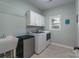 Well-equipped laundry room with modern washer and dryer, a utility sink, and ample storage cabinets at 8014 Avanti Dr, Marvin, NC 28173