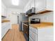 Galley kitchen with white cabinets, wood countertops, stainless steel appliances, and wood-look floors at 817 Sardis Cove Dr, Charlotte, NC 28270