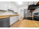 Well-lit kitchen featuring white cabinets, stainless steel appliances, and wood-look countertops and flooring at 817 Sardis Cove Dr, Charlotte, NC 28270