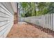 Yard featuring pine straw, brick chimney and white privacy fence bordering the property at 817 Sardis Cove Dr, Charlotte, NC 28270