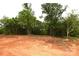 Image showcases the plot of land featuring trees and red clay at 828 Long Bow Rd, Salisbury, NC 28144