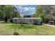 Charming home with a metal roof and a lovely front yard, set against a backdrop of lush trees at 8705 Carroll St, Hickory, NC 28601