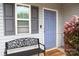 Close-up of the home's entrance featuring a gray door, window, and a welcoming bench at 8820 First Run Ct, Charlotte, NC 28215