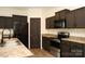 Well-lit kitchen with stainless steel appliances, granite counters and dark wood cabinets and trim at 8820 First Run Ct, Charlotte, NC 28215