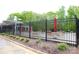 Community pool area with black metal fence, umbrellas, landscaping, and pool side chairs at 8820 First Run Ct, Charlotte, NC 28215