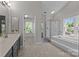 Bright bathroom featuring a soaking tub, glass-enclosed shower, and a separate walk-in closet area at 9000 Stourbridge Dr, Huntersville, NC 28078