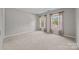 Empty bedroom with neutral carpet, two windows, and neutral colored curtains providing natural light at 9000 Stourbridge Dr, Huntersville, NC 28078