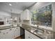 Kitchen featuring granite counters, white cabinets, a dual sink, and an open view into the living area at 9000 Stourbridge Dr, Huntersville, NC 28078