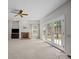 Bright living room features a fireplace, ceiling fan and access to the backyard patio through double glass doors at 9000 Stourbridge Dr, Huntersville, NC 28078