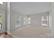 Bright living room with neutral carpet and walls and three large windows offering ample natural light at 9000 Stourbridge Dr, Huntersville, NC 28078