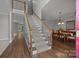 Open staircase with hardwood floors and a view of the dining room at 9000 Stourbridge Dr, Huntersville, NC 28078